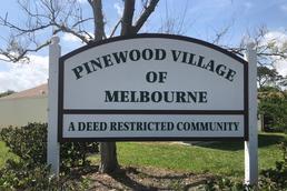 Pinewood Village of Melbourne — A Deed Restricted Community sign